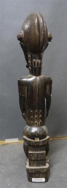 null BAOULE - COTE D'IVOIRE Figurine en bois sculpté patiné figurant un homme assis...