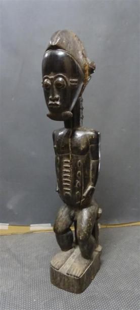 null BAOULE - COTE D'IVOIRE Figurine en bois sculpté patiné figurant un homme assis...