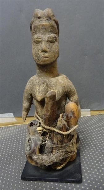 null FON - BENIN Statuette en bois sculpté patiné figurant une femme à laquelle est...