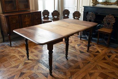 MOBILIER Table de salle à manger rectangulaire à trois allonges en noyer. Pieds tournés...