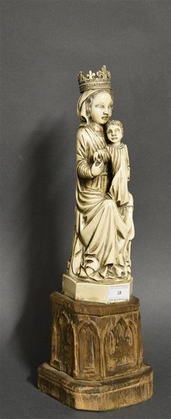 OBJETS D'ART Vierge à l'enfant en ivoire sur un socle en bois sculpté Début du XXe...