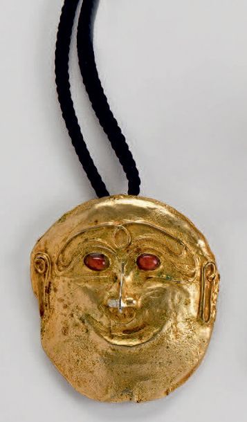 TRAVAIL CONTEMPORAIN Broche-pendentif masque en métal doré, les yeux sertis de cabochons...