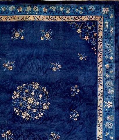 CHINE Important tapis à fond bleu nuit à décor central d'une rosace fleurie et semis...
