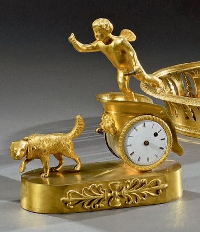 null Très petite pendule en bronze doré, figurant sur un char traîné par un chien,...