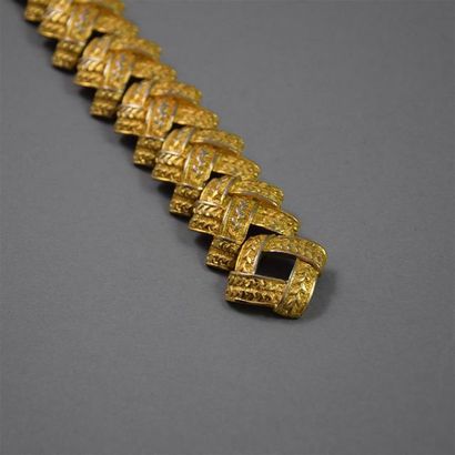 null GUY LAROCHE, circa 1980. Bracelet en métal doré articulé figurant des rubans...