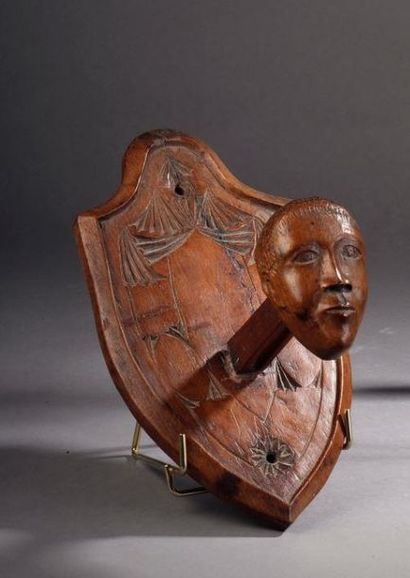  Patère figurant une tête d'homme montée sur un écusson en bois sculpté XIXe siècle...