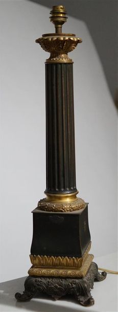 null Une lampe en bronze patiné et doré, le fût cannelé à chapiteau corinthien reposant...