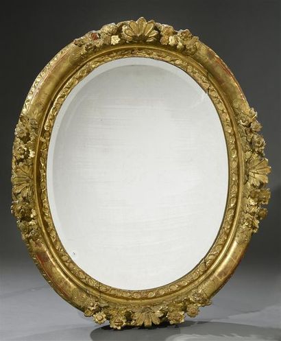 null Cadre ovale en bois doré et sculpté de fleurs et coquilles, foncé un miroir...