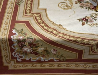  Grand tapis au point, à décor d'un médaillon central fleuri dans un large encadrement...