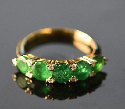 null Bague jarretière en or jaune 18K (750°/°°) ornée d'une ligne d'émeraudes rondes...