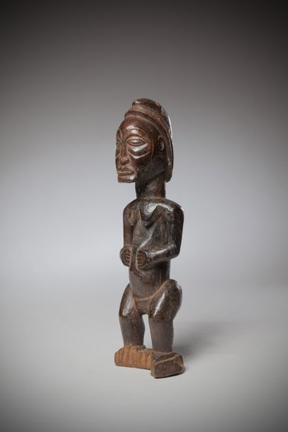 null LUBA/HOMBO, Congo (RDC). Statue féminine en bois lourd patiné par l’usage. La...