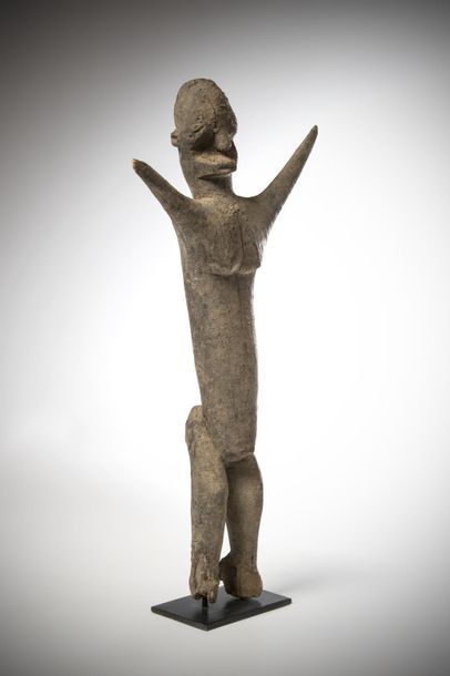 null LOBI, Burkina Faso. Statue sitting with both arms raised. The elongated torso...