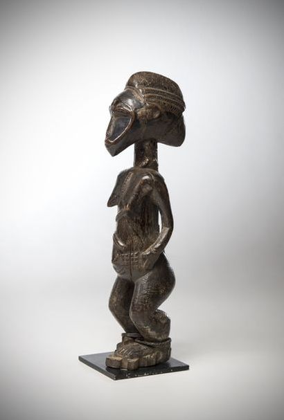 null BAOULE, Ivory Coast. Female statue with elongated face in triangle and headdress...