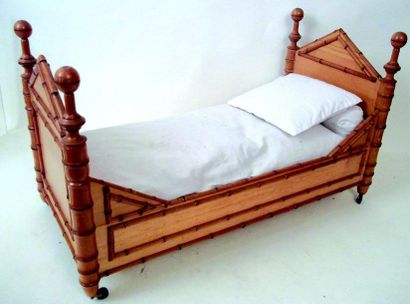  Un lit en pitchpin avec sa literie aux initieles “B”. Format: 55x30x35 cm