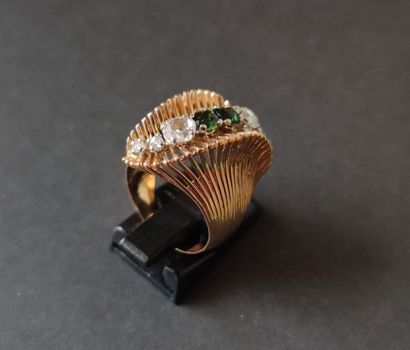 null Winding ring in 18K (750) gold, adorned with a line of two peridots between...
