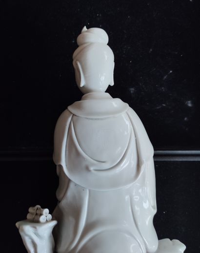 null 
STATUTE in white porcelain representing Kwan-In sitting on a rock, stamp on...