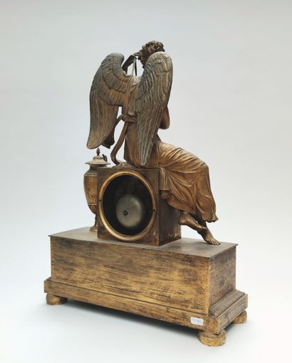 null 
Gilt bronze clock with a winged woman dressed in the antique style sitting...