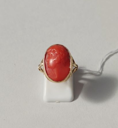 null 
Yellow gold ring set with a red coral cabochon with a man's profile. Gross...