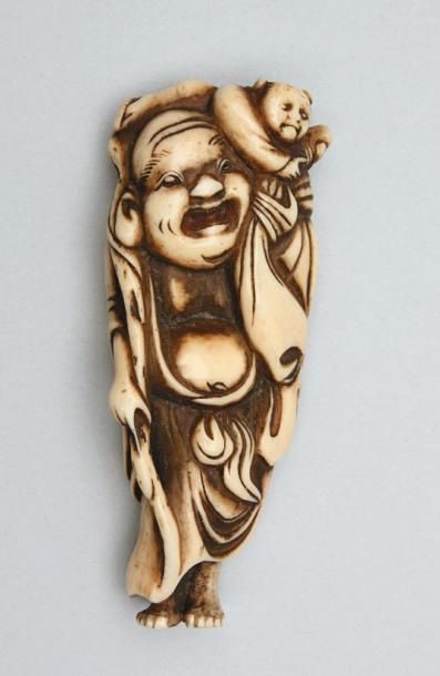 JAPON NETSUKE en ivoire patiné représentant un homme debout tenant un bâton avec...