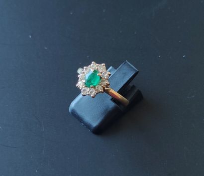  Yellow gold ring set with an emerald and a circle of brilliant-cut diamonds Gross...