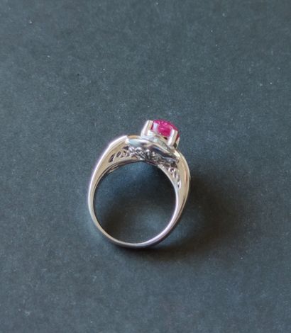 null 
PLATINUM RING set with a 6.54 carat cabochon ruby in a setting of two trapers...