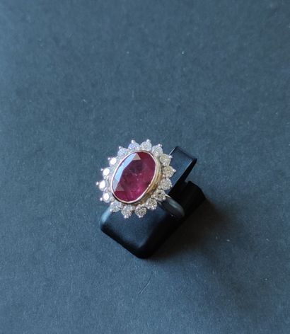 null 
RING in GREY gold 750°/00 set with a ruby of about 4 carats and a circle of...
