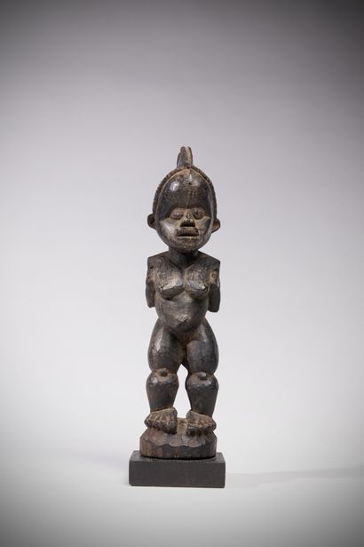 null Boki / M'bembe (Nigeria) This powerful female sculpture with arms folded upward...