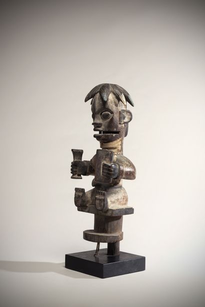 null Ogoni (Nigeria) Polychrome wooden puppet statue in a seated position, holding...