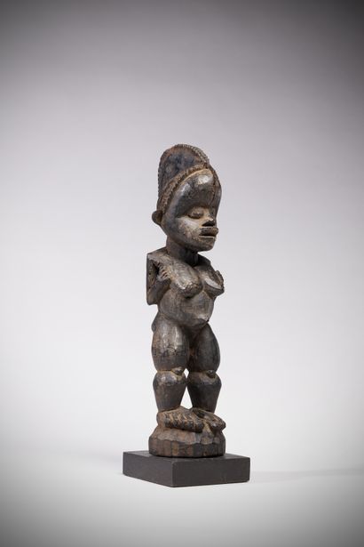 null Boki / M'bembe (Nigeria) This powerful female sculpture with arms folded upward...