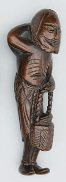 null NETSUKE en bois représentant un sennin tenant un panier. Japon, XIXe siècle....