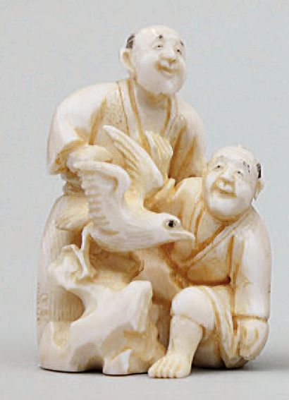 null NETSUKE OKIMONO en ivoire représentant deux hommes s'amusant avec un oiseau...