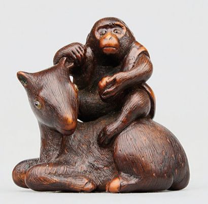 null NETSUKE en bois représentant un singe assis sur un daim couché. Leurs yeux sont...
