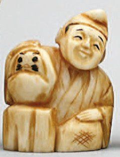 null NETSUKE en ivoire représentant un homme assis à côté d'une poupée Daruma. Japon,...