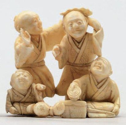 null NETSUKE-OKIMONO en ivoire représentant trois hommes jouant avec un enfant et...