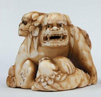 null NETSUKE en ivoire représentant trois shishi jouant, signé Shokiusaï. Japon,...