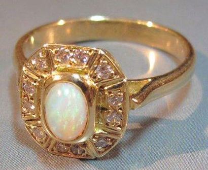 null Bague en or jaune 18 K sertie d 'une opale ovale cabochon entourage de diamants...