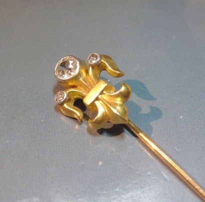 null Epingle de cravate en or jaune à décor d'une fleur de Lys, sertie d'un diamant...