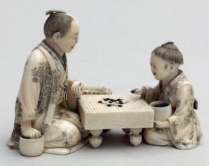 null OKIMONO en ivoire représentant un père et son fils jouant au jeu de Go tenant...