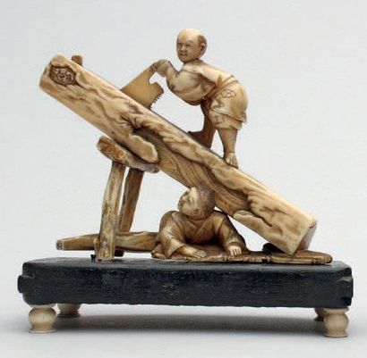 null OKIMONO en ivoire représentant deux bûcherons, l'un sciant un tronc d'arbre....