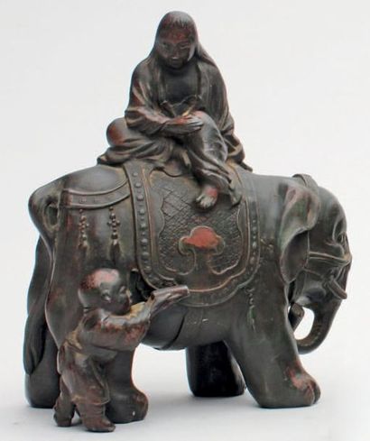 null STATUETTE en métal patiné représentant Kwannon assise sur un éléphant, un jeune...