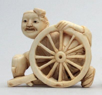 null NETSUKE en ivoire représentant un homme fabriquant une roue, signé Giokkuzan....