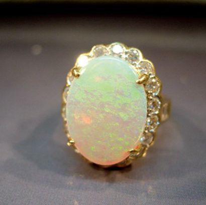 null BAGUE EN OR JAUNE centrée d'une opale ovale entourage de diamants taille brillant....