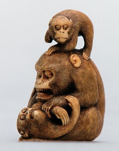 null NETSUKE en ivoire représentant une guenon jouant avec ses deux petits. Signé...