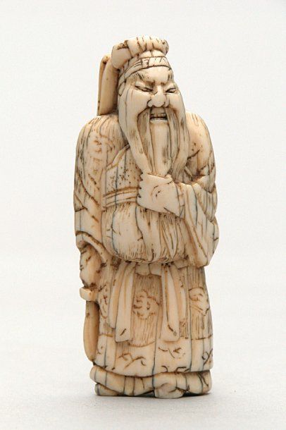 null NETSUKE en ivoire représentant Kwanyu debout vêtu d'un costume chinois caressant...