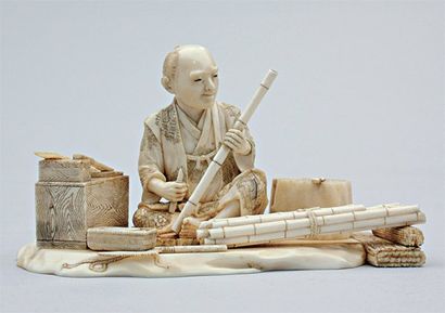 null OKIMONO en ivoire représentant un artisan assis taillant des bambous, ses outils...