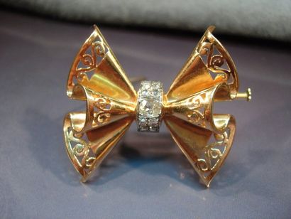 null Broche ruban en or jaune repercé et platine sertie de diamants taille ancienne....