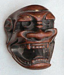 NETSUKE en bois représentant un masque d'homme grimaçant. Signé Tametaka. Japon,...
