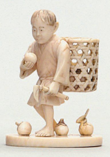  OKIMONO en ivoire représentant un enfant récoltant des kakis. Signé Ryomin. Japon,...