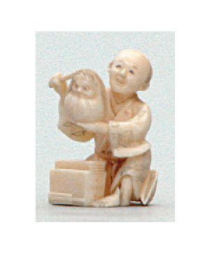 null PETIT OKIMONO en ivoire représentant un artisan, une poupée Daruma à la main....