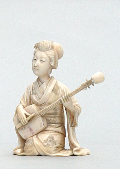 null OKIMONO en ivoire représentant une geisha musicienne jouant du shamisen. Signé....